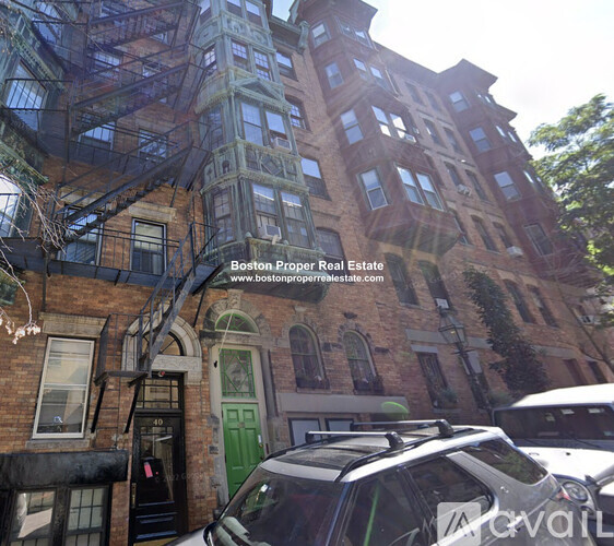 A building with a green door and a sign that says Boston Proper Real Estate.