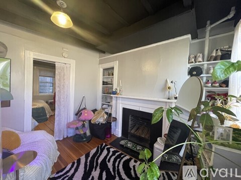 A living room with a zebra rug and a fireplace.