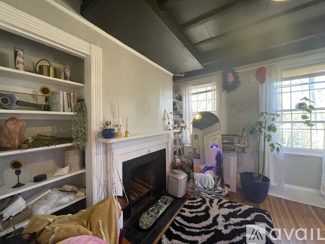 A living room with a fireplace and a zebra print rug.