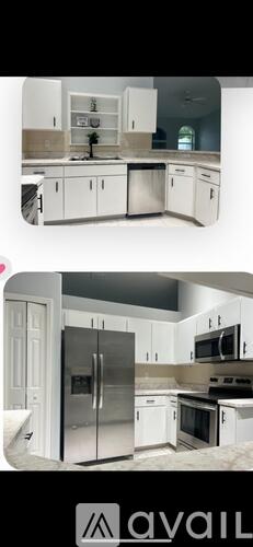 A kitchen with white cabinets and a stainless steel refrigerator.