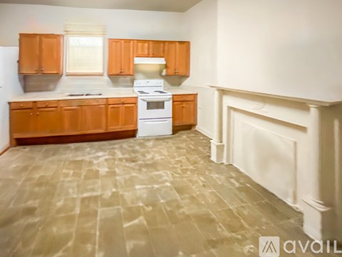 A kitchen with wooden cabinets and a white stove top oven.