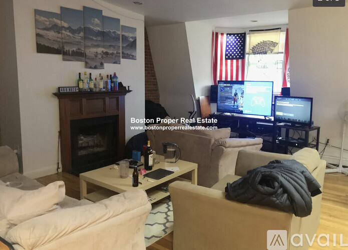 A living room with a fireplace, couches, and a television.