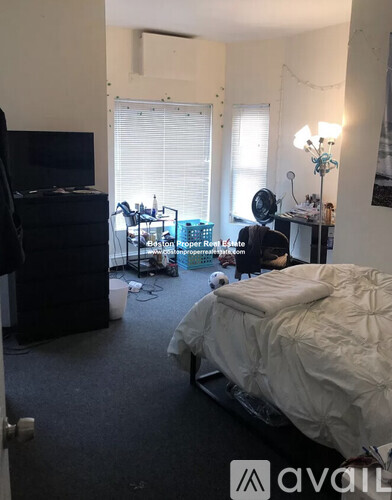 A bedroom with a bed, desk, and chair.