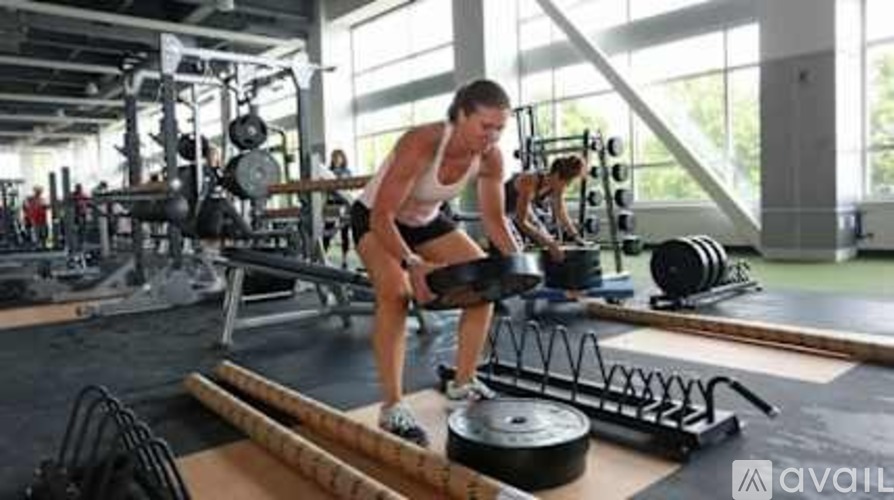 A man is working out in a gym with a barbell.