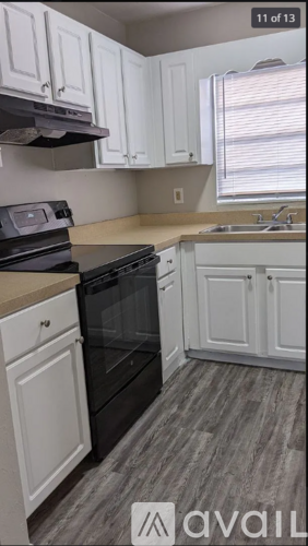 A kitchen with white cabinets and a black oven.