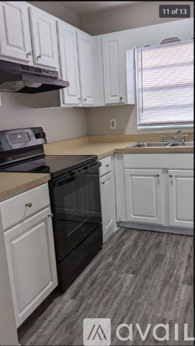 A kitchen with white cabinets and a black oven.
