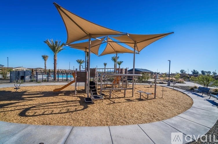 A playground with a shaded area and a slide.