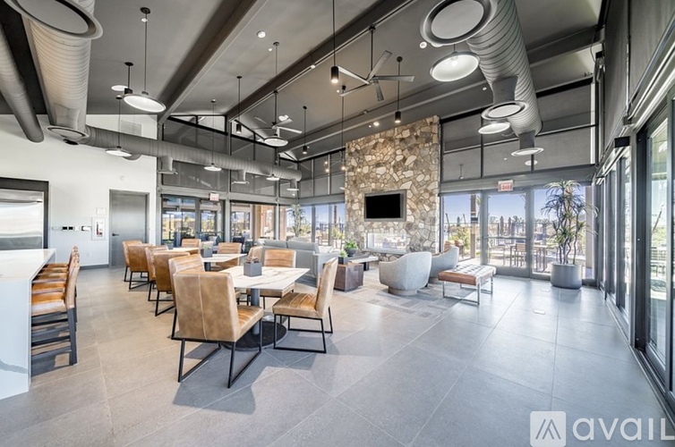 A modern dining room with a stone fireplace and large windows.
