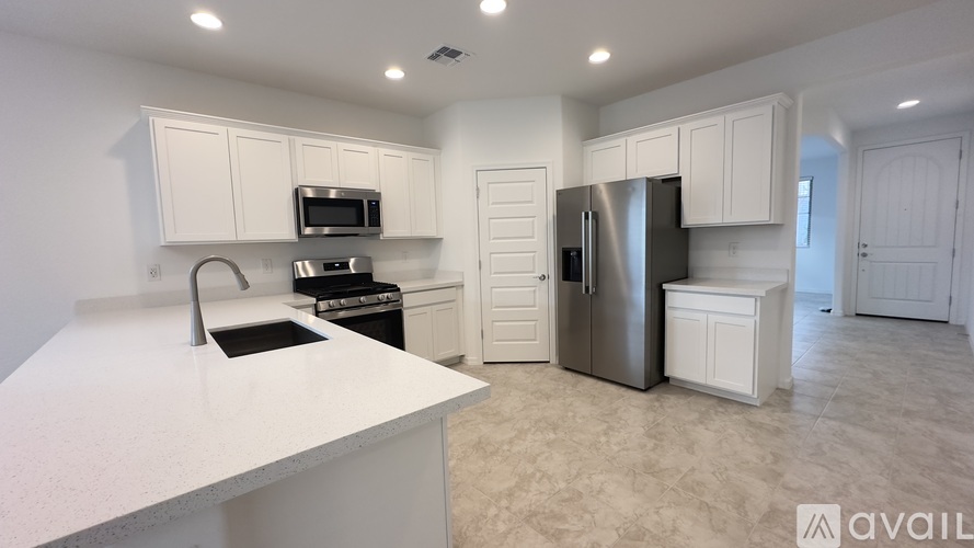 A kitchen with white cabinets and appliances is available for rent.