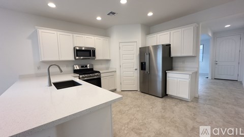 A kitchen with white cabinets and appliances is available for rent.