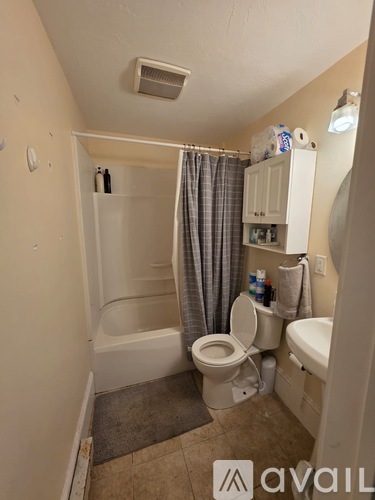 A small bathroom with a toilet, sink, and bathtub.