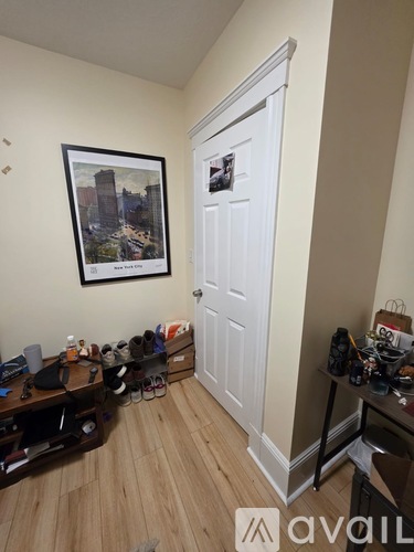 A room with a white door and a framed picture on the wall.