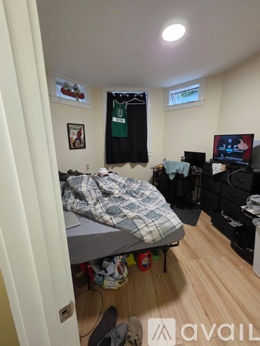 A bedroom with a bed, desk, and a window.