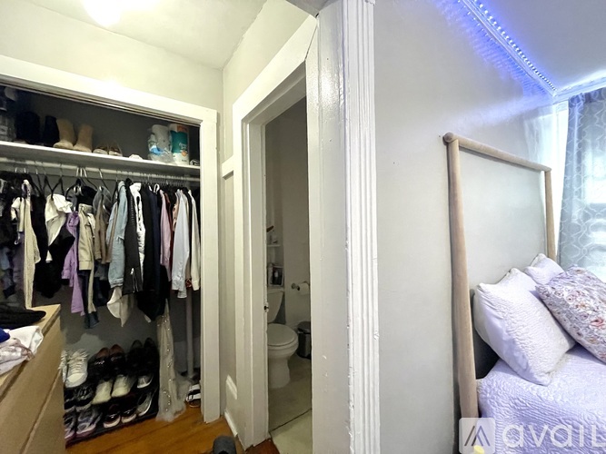A bedroom with a bed, a wardrobe, and a mirror.
