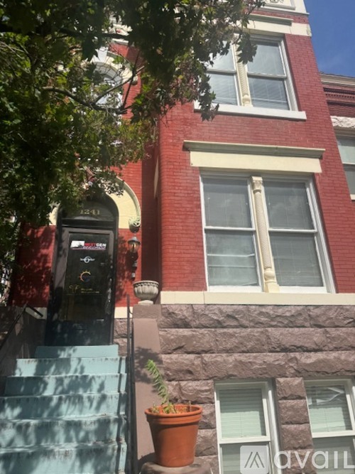 A red brick building with a window and a sign that says "available".