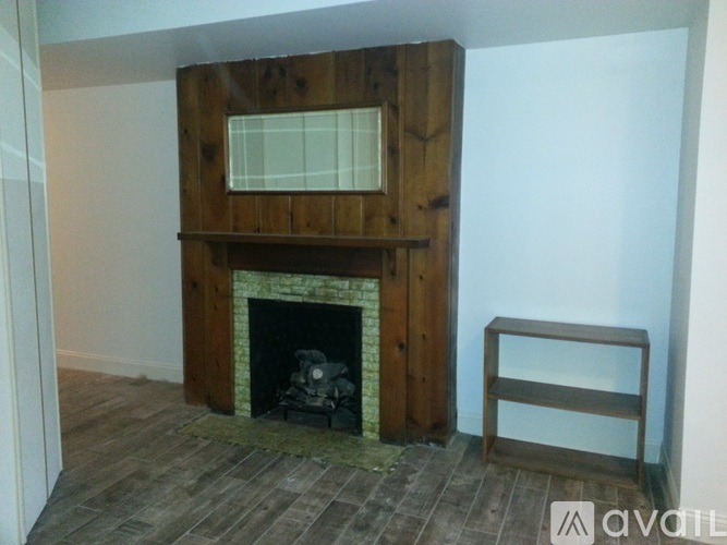 A wood burning stove in a room with a wooden mantle and a shelf.