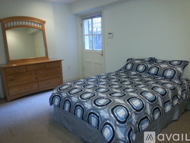 A bedroom with a bed, dresser, and mirror.