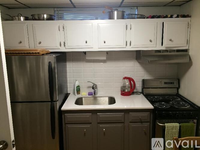 A kitchen with a stainless steel refrigerator and a stove top oven.