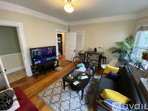 A living room with a black couch and a television.