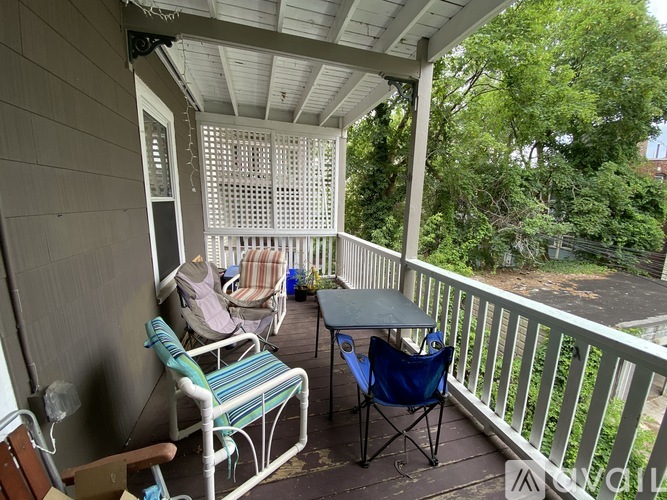 A porch with a table and chairs and a screened in area.