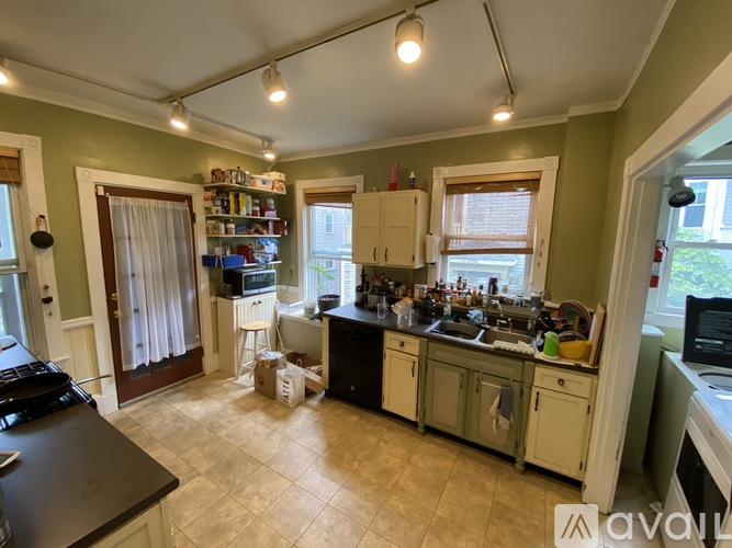 A kitchen with a black counter top and white cabinets.