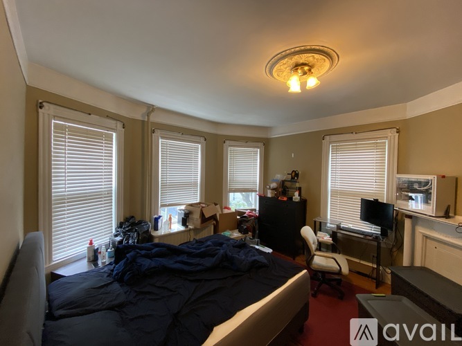 A bedroom with a bed, desk, and chair.