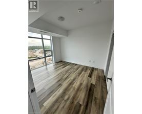 A room with wooden flooring and a large window overlooking a construction site.