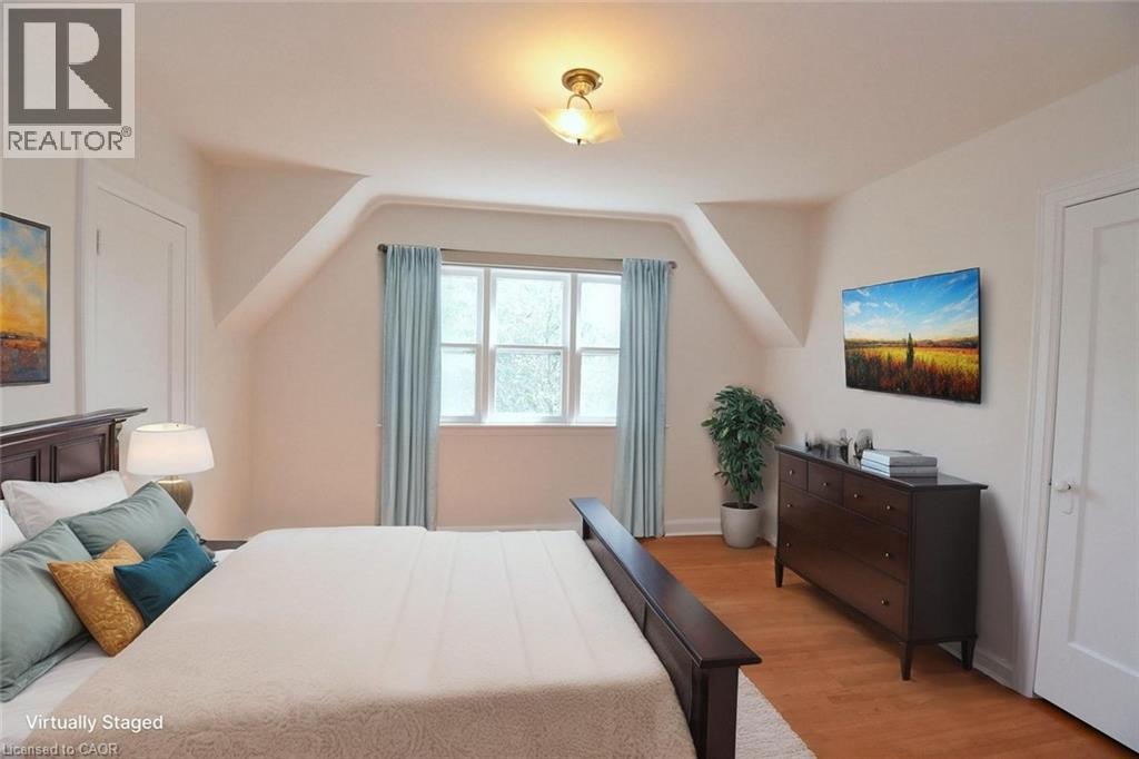 A bedroom with a bed, dresser, and window.