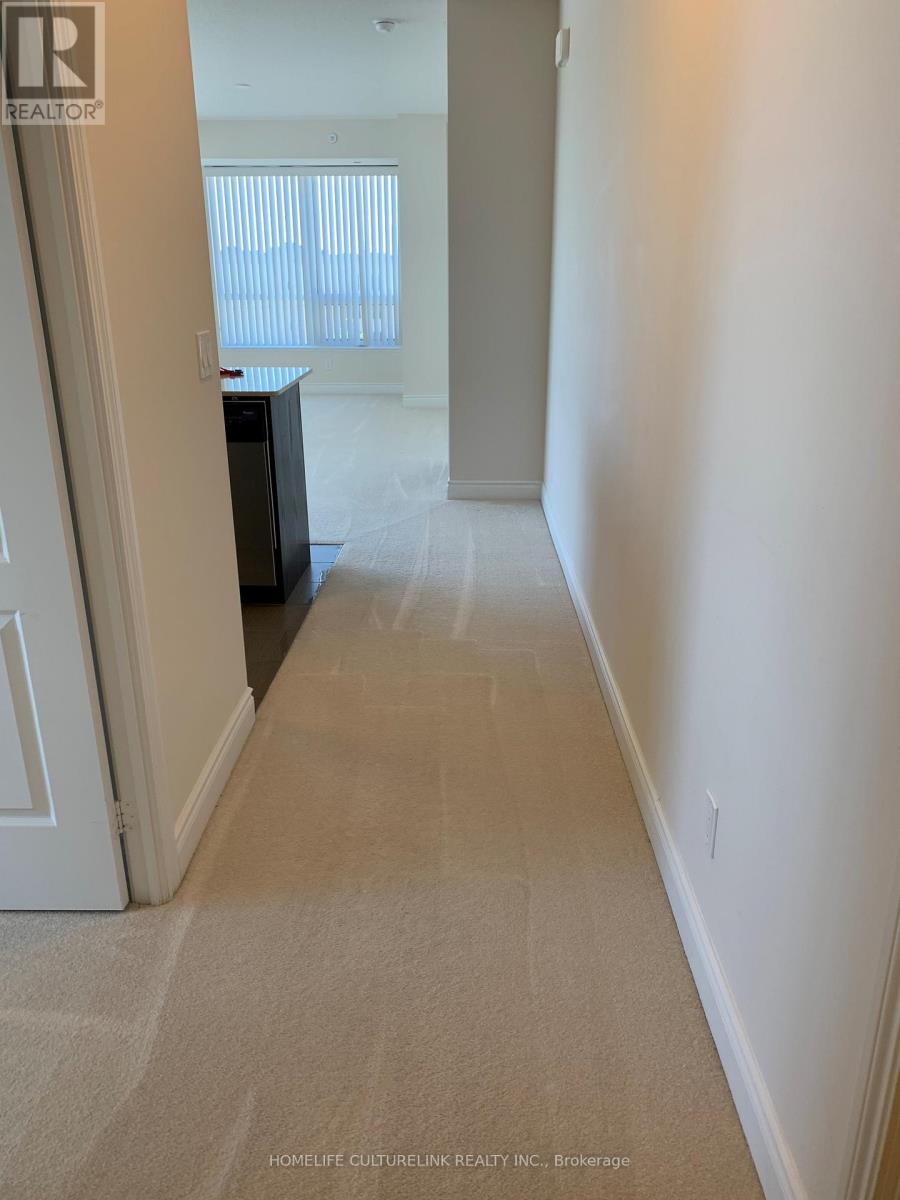 A hallway with a carpeted floor and white walls.