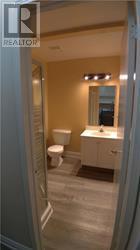 A bathroom with a toilet, sink and mirror.