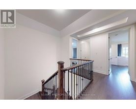 A spacious room with a staircase leading to the upper floor.