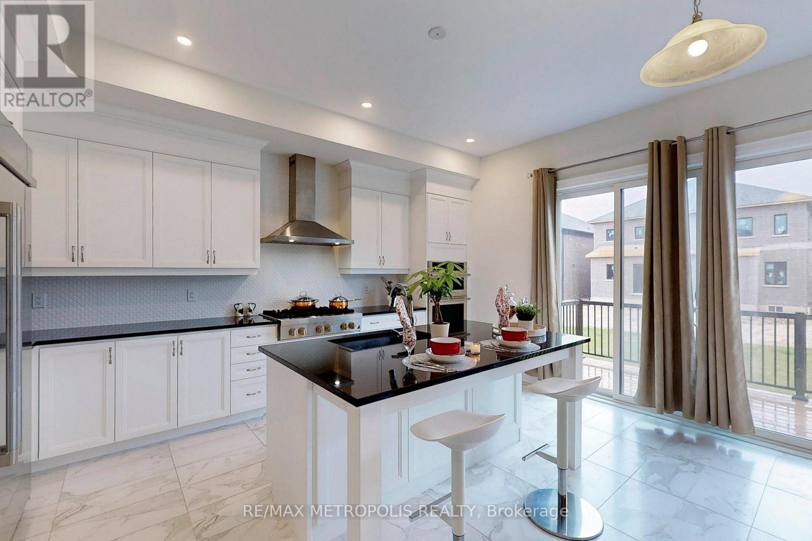 A modern kitchen with white cabinets and a black countertop.