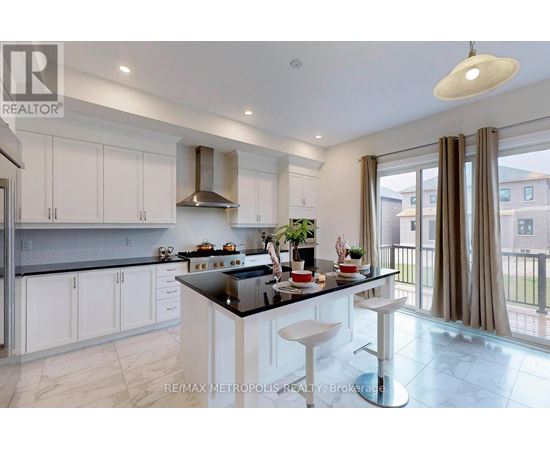 A modern kitchen with white cabinets and a black countertop.