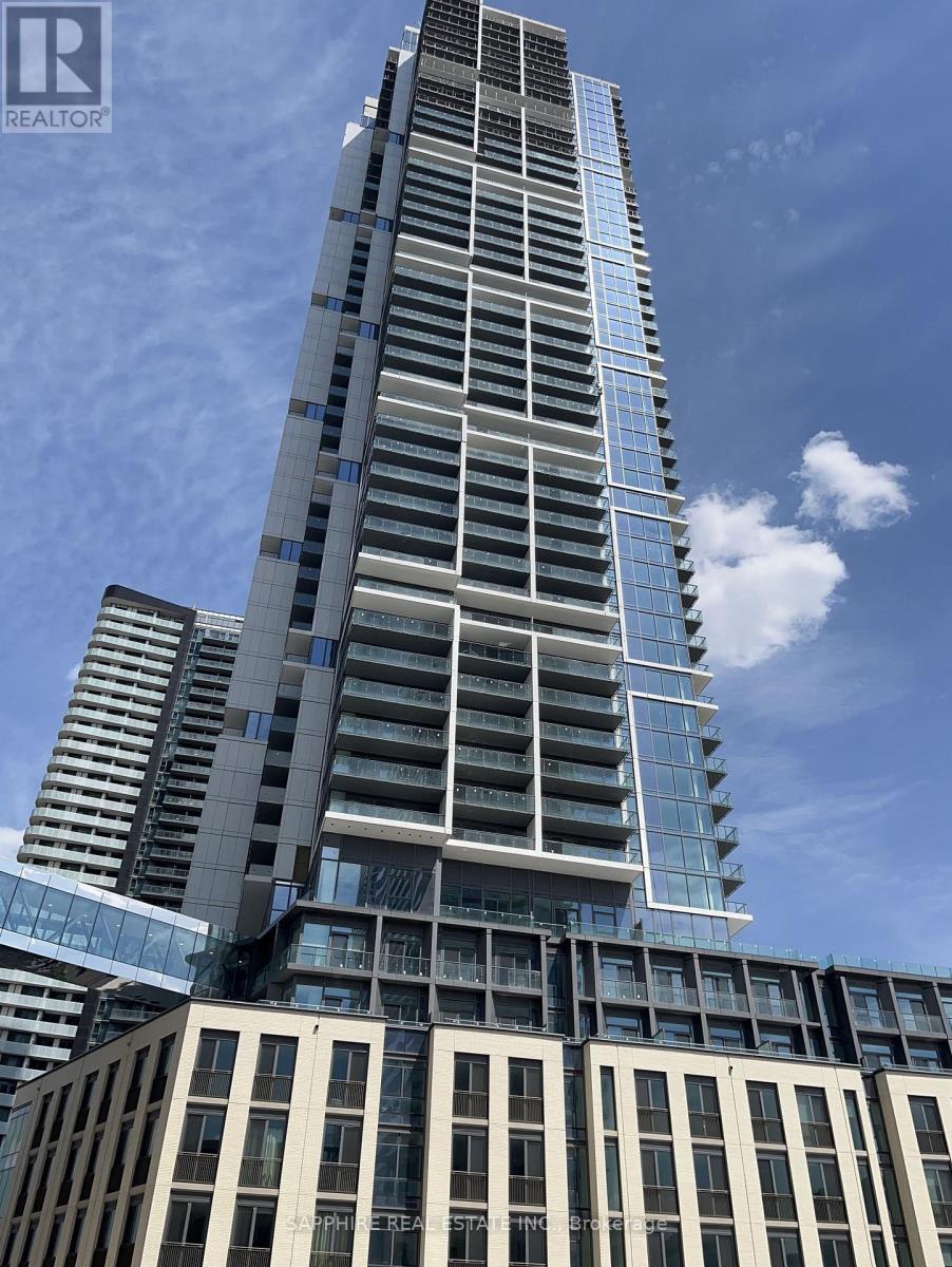 A tall building with a glass facade stands under a blue sky.