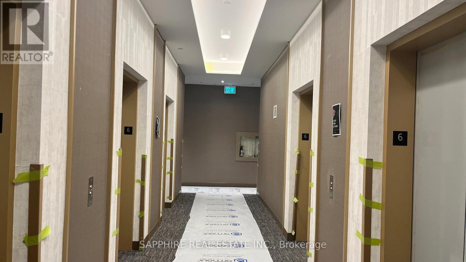 A hallway with doors on both sides and a sign that says "EXIT".