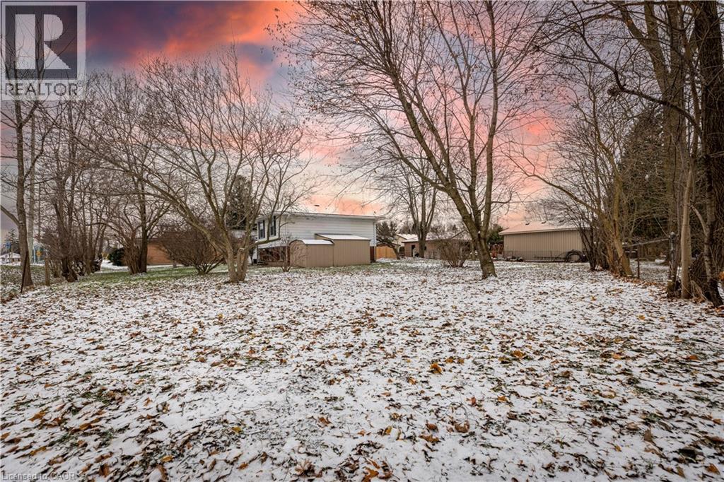 A house is surrounded by trees and covered in snow.