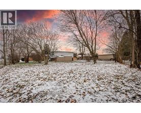 A house is surrounded by trees and covered in snow.