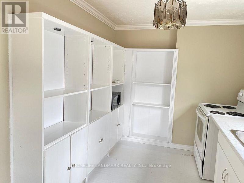 A kitchen with white cabinets and a stove top oven.