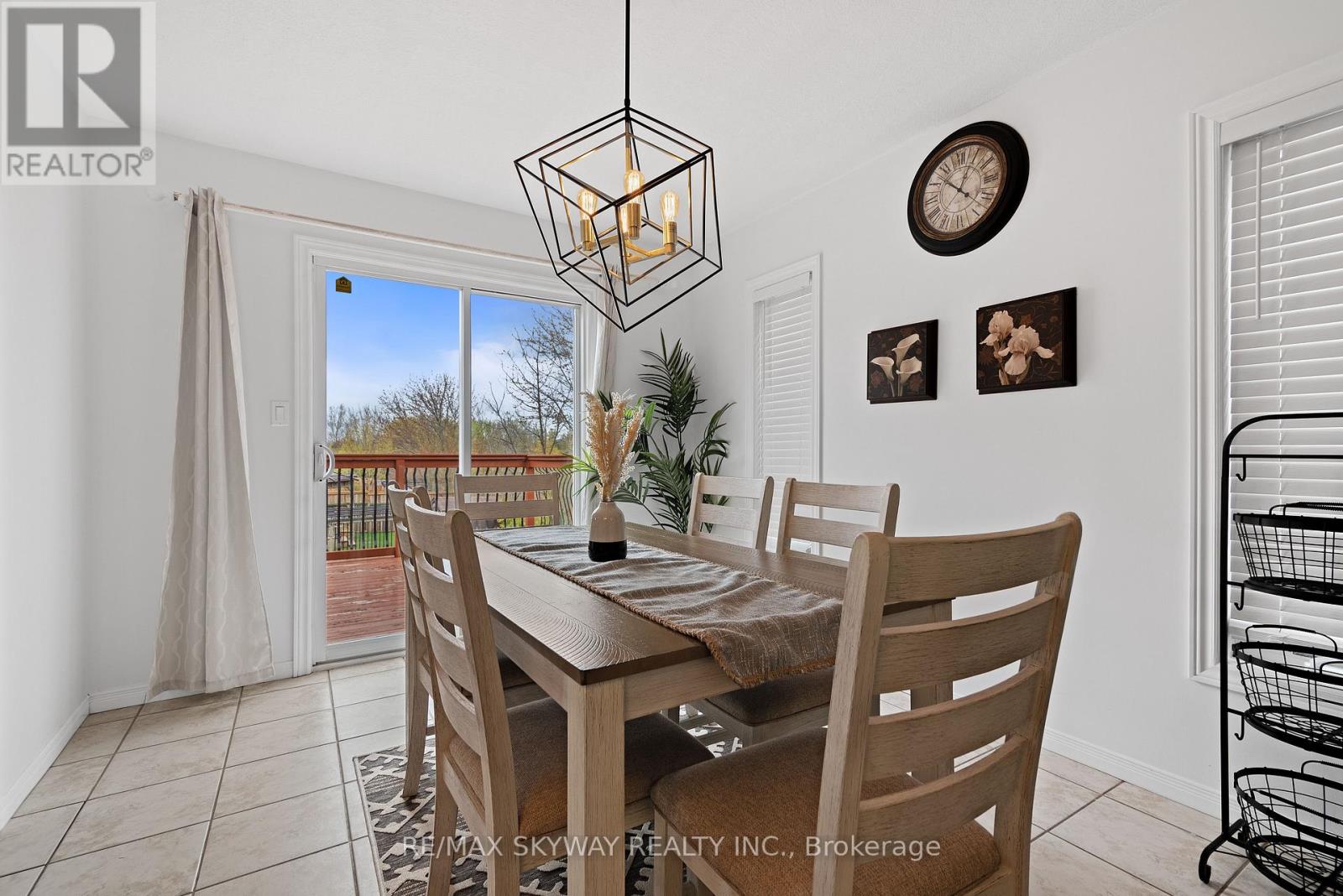 A dining room with a table set for four and a view of a backyard.