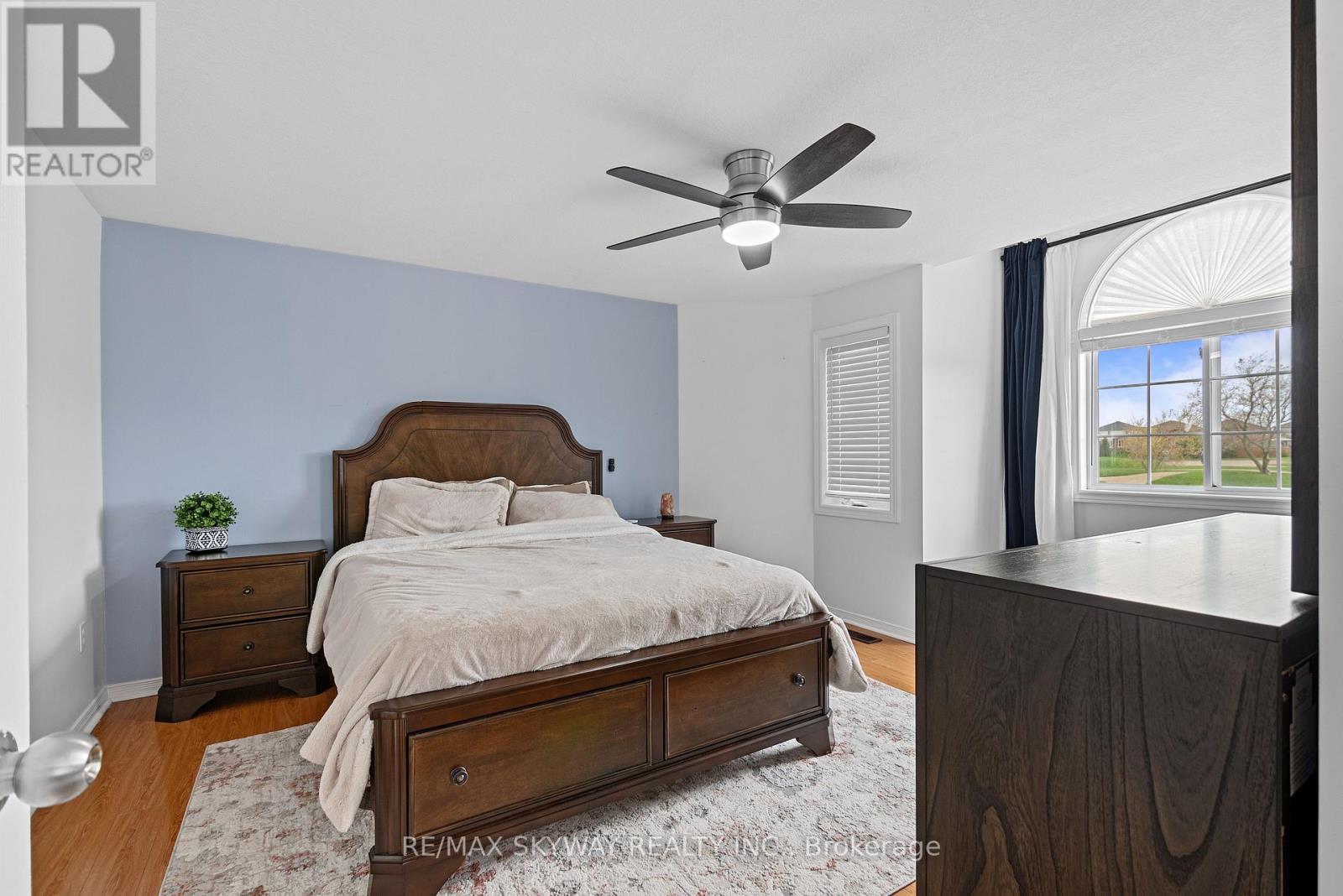 A bedroom with a bed, nightstand, and dresser.