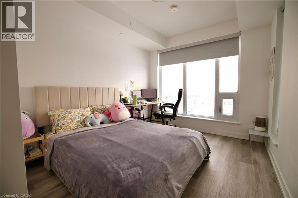 A bedroom with a large bed and a window with blinds.