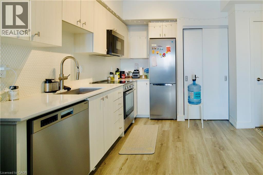 A kitchen with white cabinets and a refrigerator.