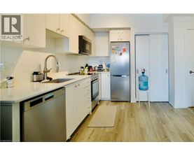 A kitchen with white cabinets and a refrigerator.