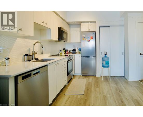 A kitchen with white cabinets and a refrigerator.