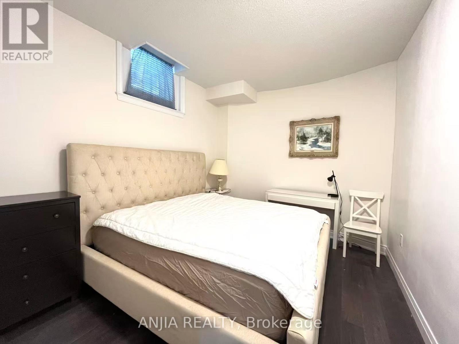 A bedroom with a large bed and a small table.