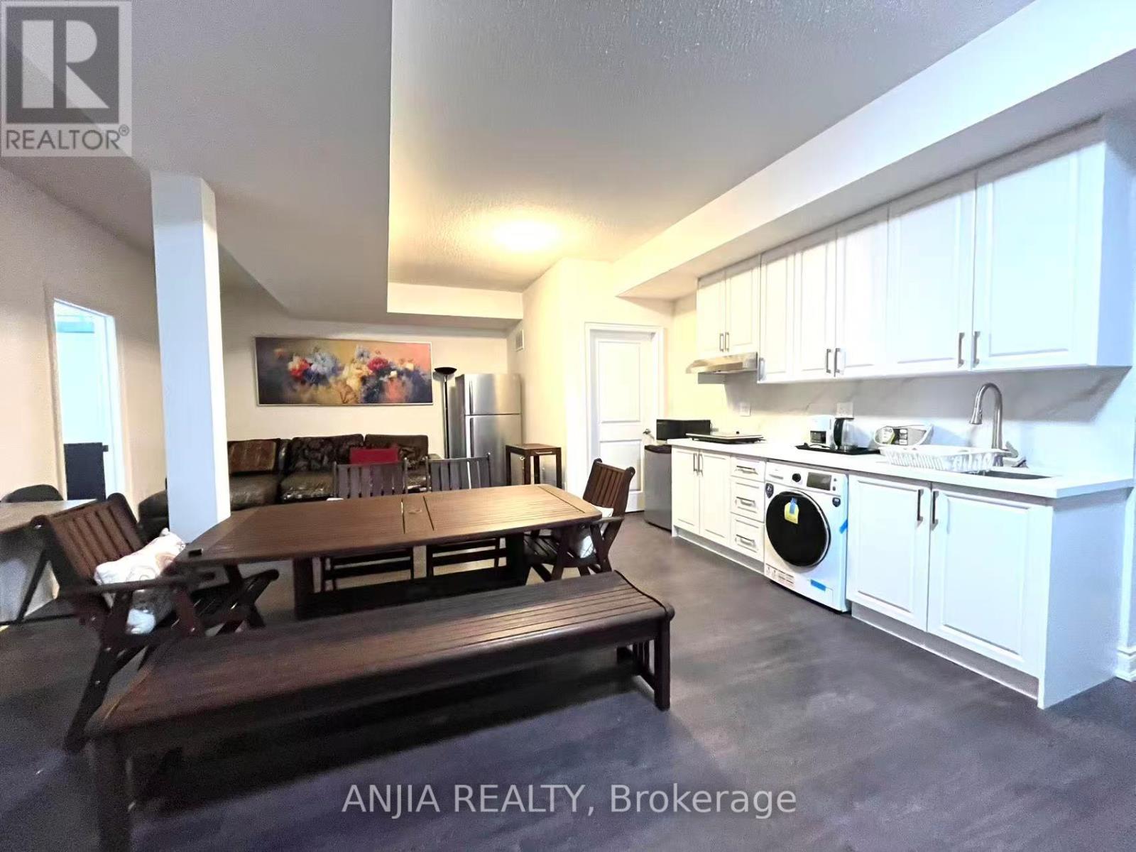 A kitchen with white cabinets and a wooden table.