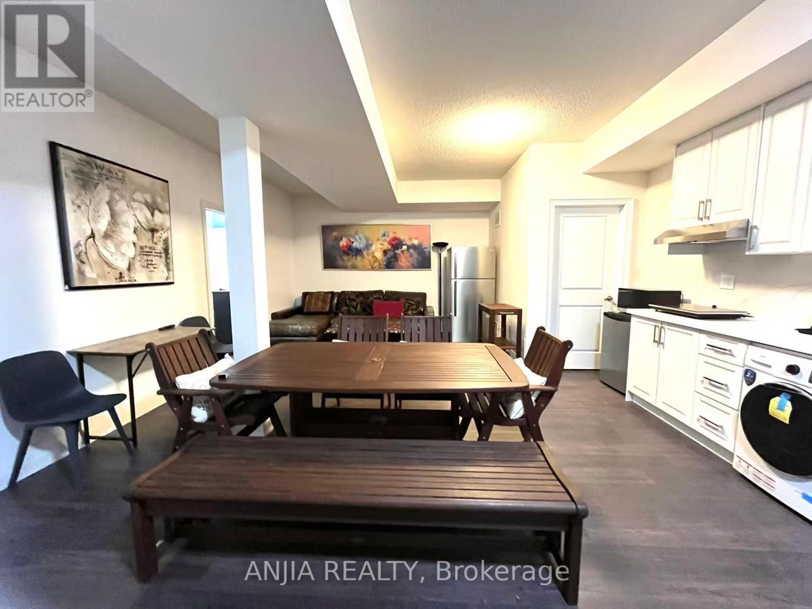 A dining room with a wooden table and chairs.