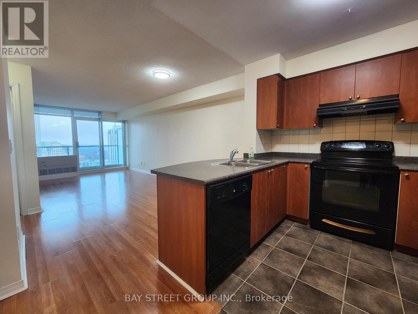 A kitchen with wooden cabinets and black appliances.