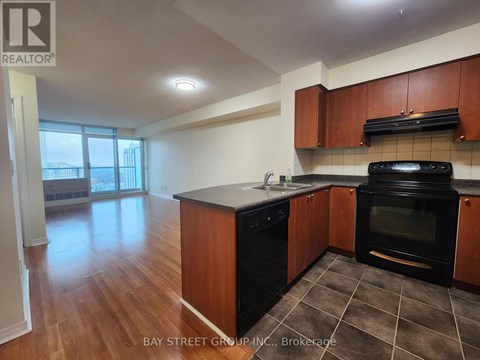 A kitchen with wooden cabinets and black appliances.