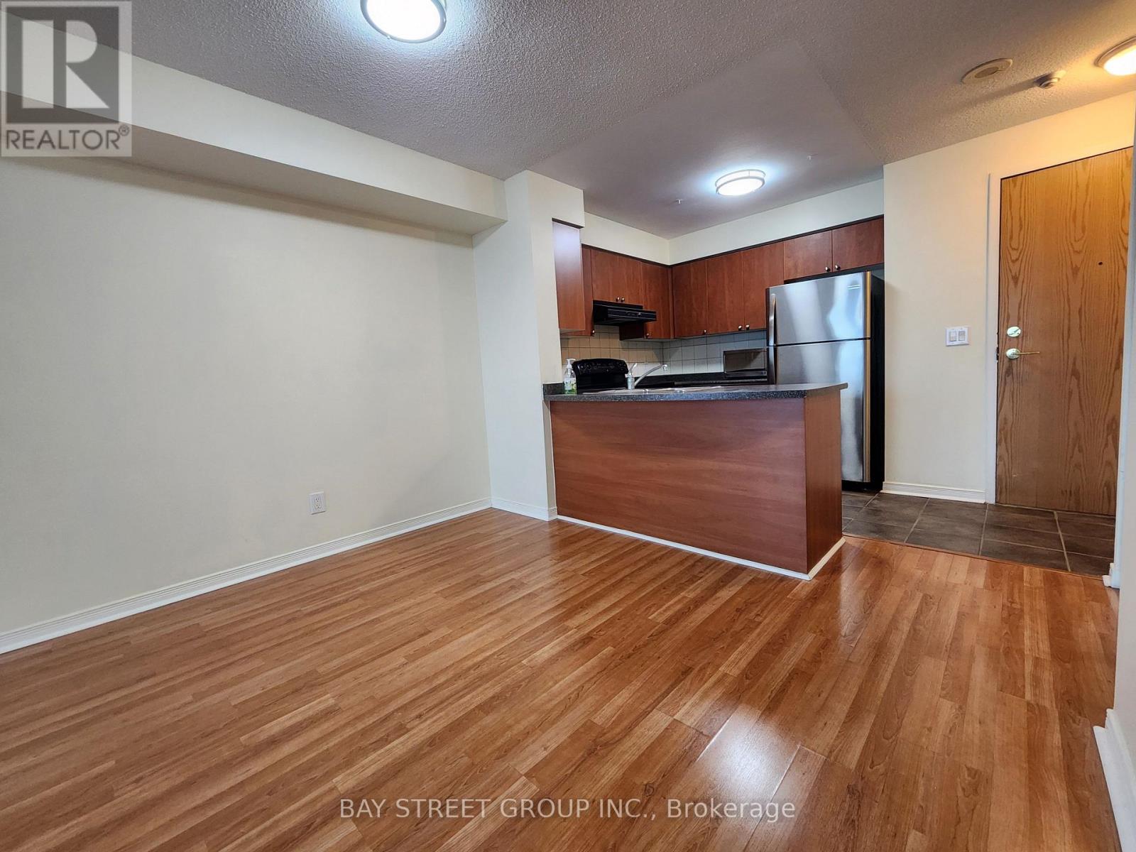 A kitchen with wooden floors and a refrigerator.